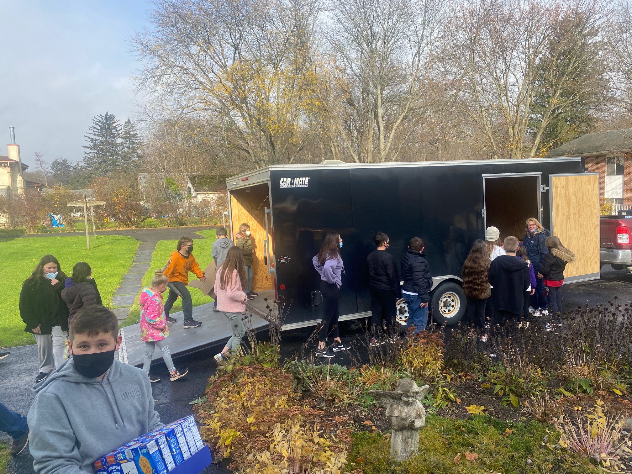 Students from JEMS and EE team up to unload donated food at the local food pantry