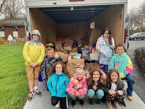 Students from JEMS and EE team up to unload donated food at the local food pantry