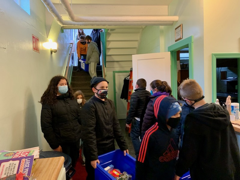 Students from JEMS and EE team up to unload donated food at the local food pantry