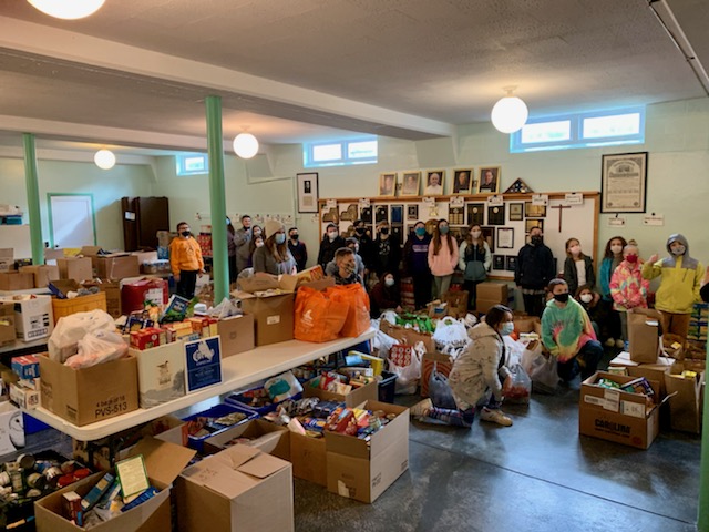 Students from JEMS and EE team up to unload donated food at the local food pantry