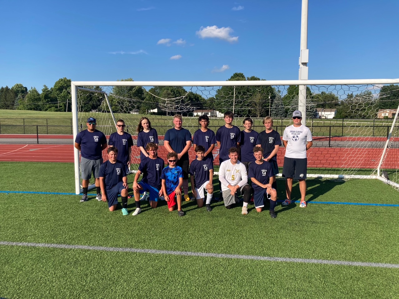 The varsity boys soccer team poses for a photo during summer training
