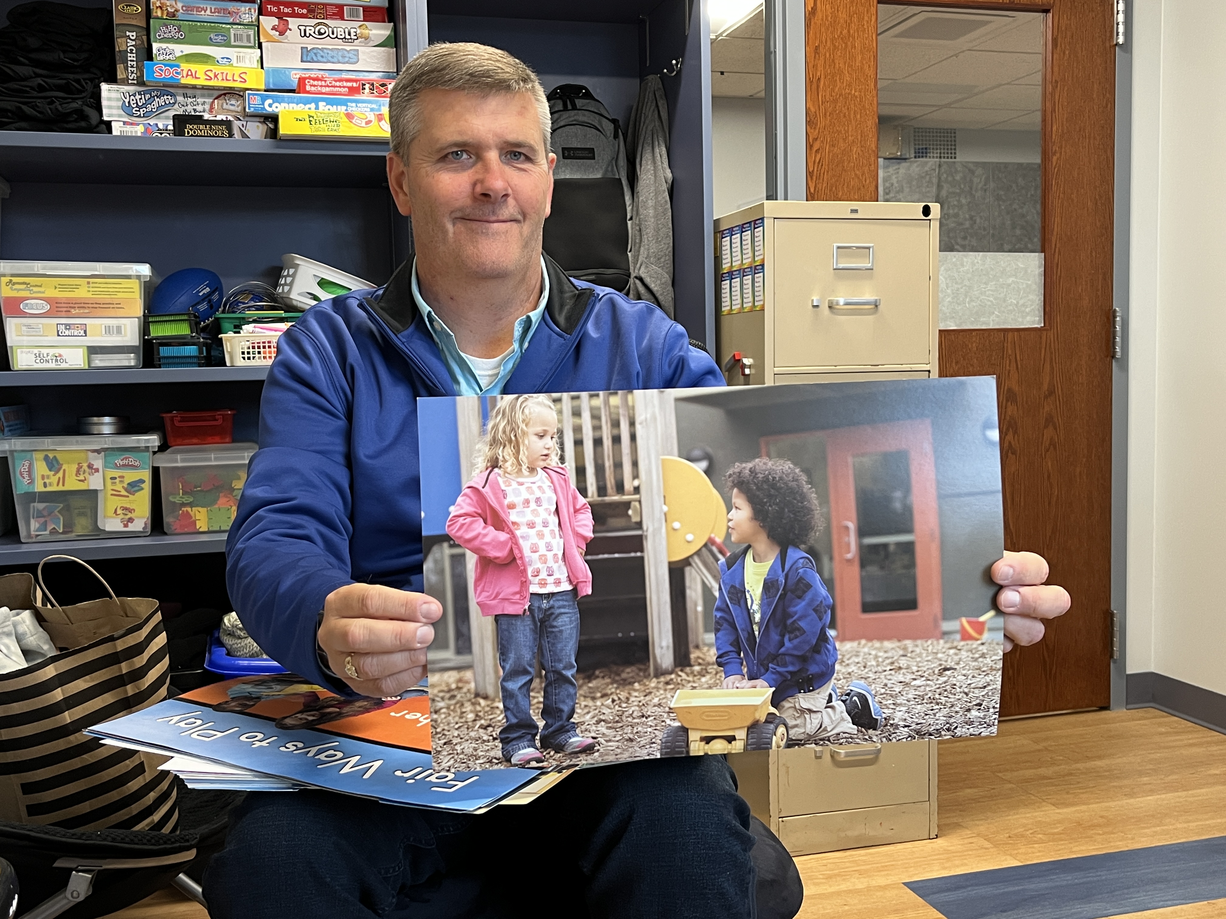 Counselor Rob McIntyre shows an example of a "Second Step Curriculum" poster, highlighting a student-behavior